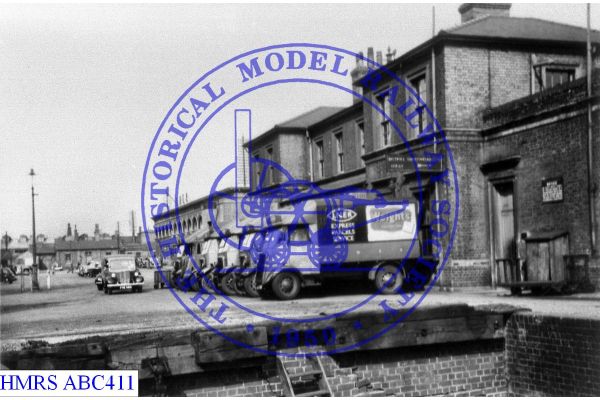 [ABC411] LNE parcels vans at Cambridge, loading dock foreground, station offices background Six vans line abr