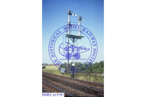 [ACF983] Langham junction, rear UQ Up bktHDsignal with goods line arm right Tracks foreground.