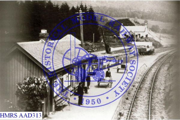 [AAD313] Station building. Handcarts used as barrows on platform.